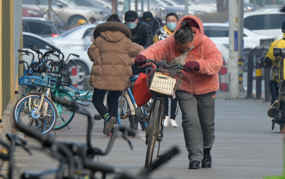 沈阳迎来黄尘大风天气 街头市民顶风骑行