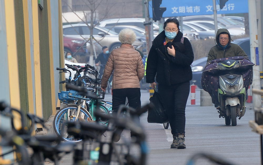 沈阳迎来黄尘大风天气 街头市民顶风骑行