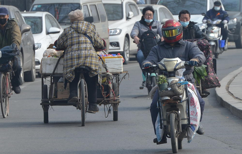 沈阳迎来黄尘大风天气 街头市民顶风骑行