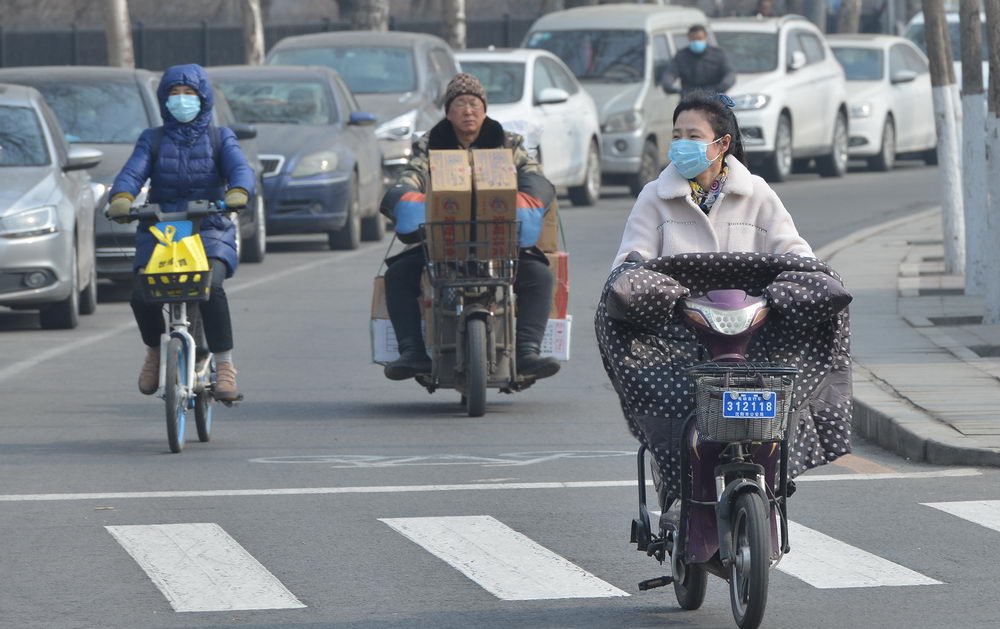 沈阳迎来黄尘大风天气 街头市民顶风骑行