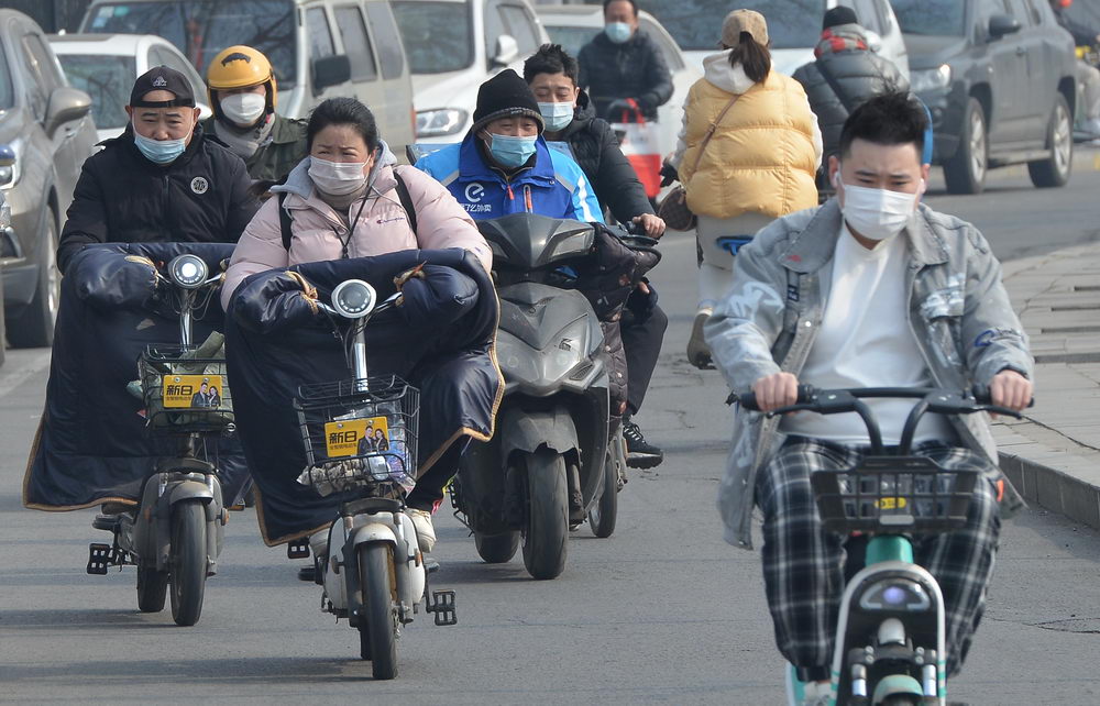 沈阳迎来黄尘大风天气 街头市民顶风骑行