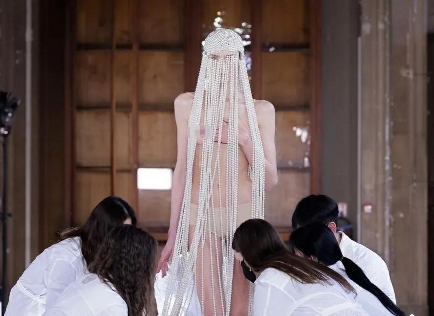 模特在巴黎时装秀上用珍珠绳遮住身材