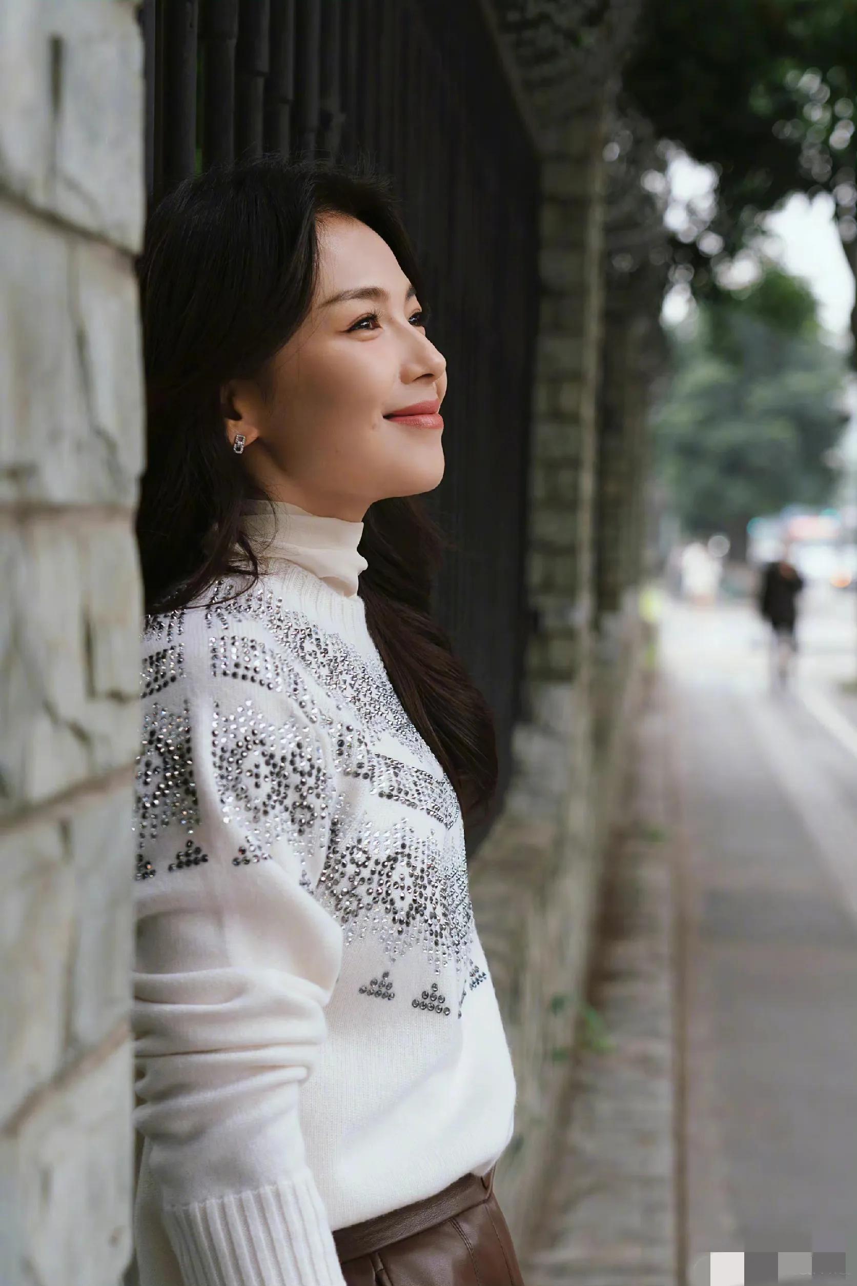 刘涛晒街拍照，白色针织衫搭配皮裤，温婉大气，优雅知性。