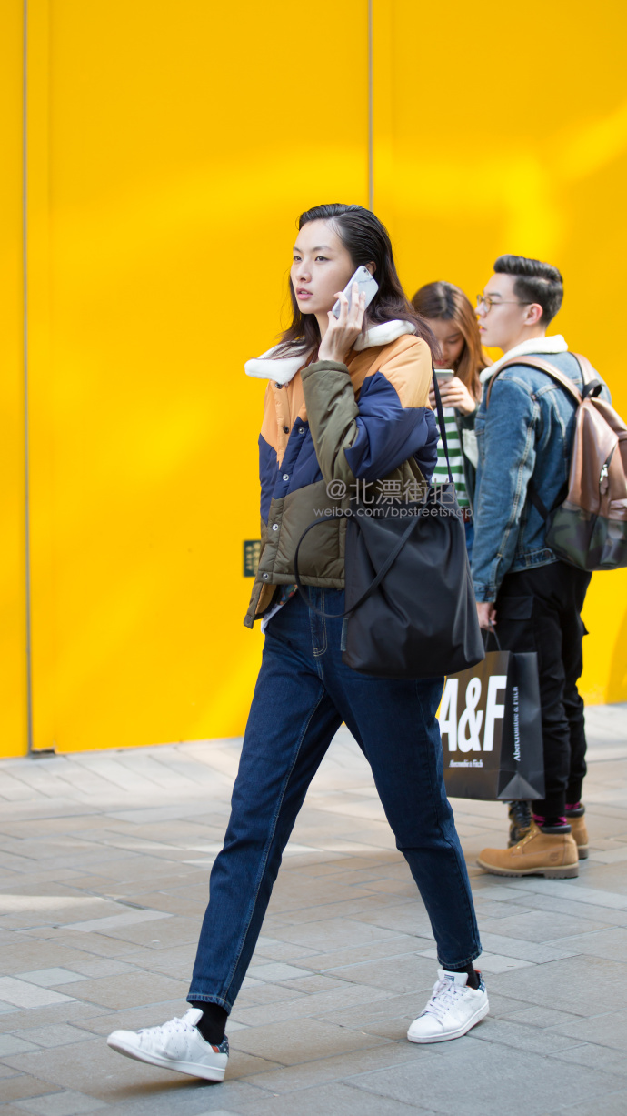 北京街拍：橙蓝褐拼接棉服搭配酷酷蓝牛仔裤，英气十足