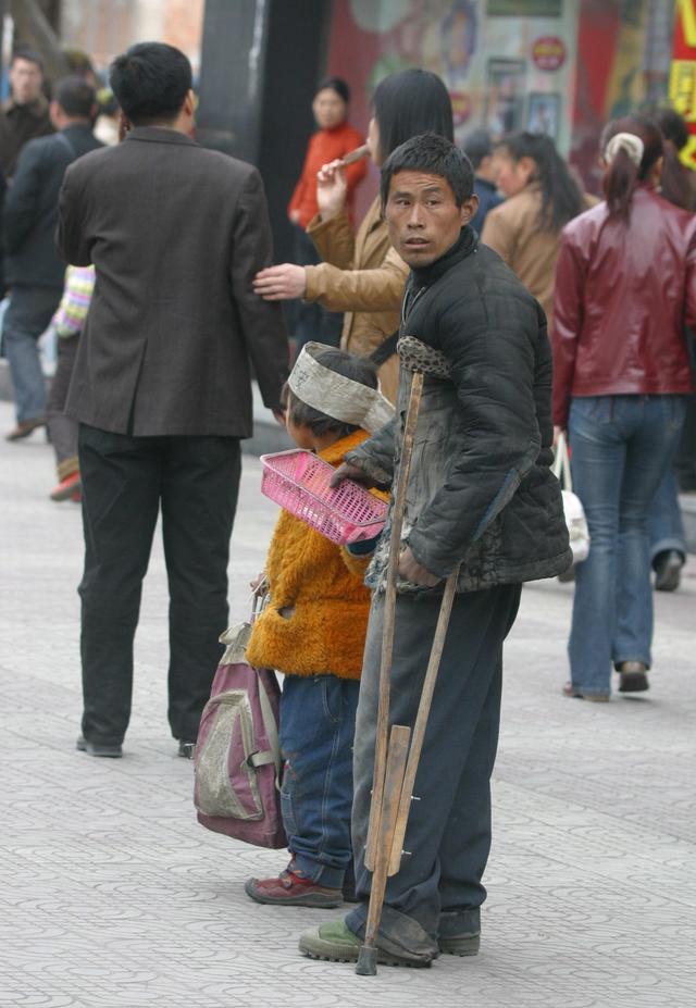 坑队友！郑州街头大妈卖力乞讨，大爷却在偷偷玩手机，被人揭穿
