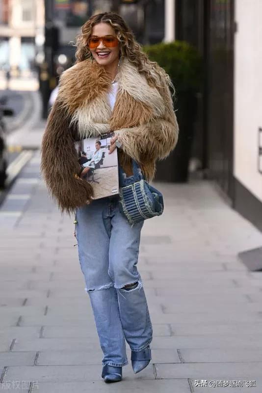 瑞塔·奥拉身穿短皮草外套+牛仔裤+牛仔包时髦个性
