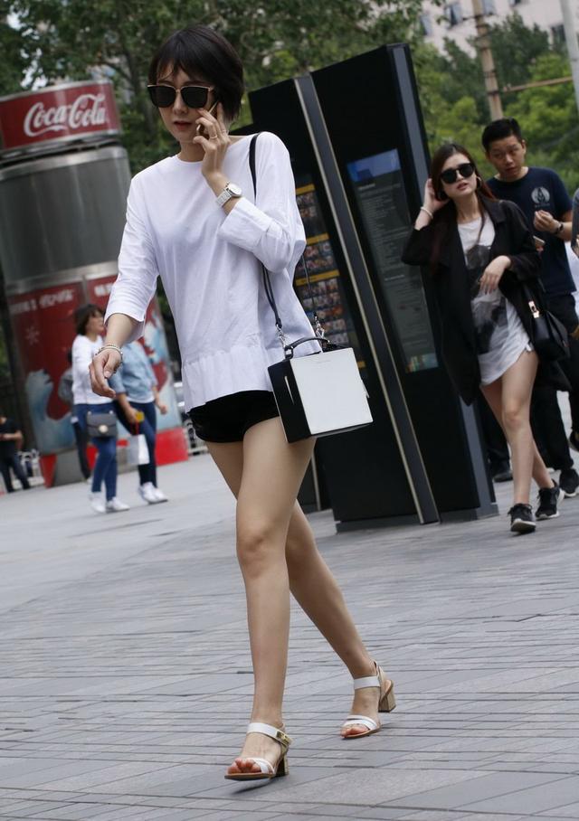 街拍超短热裤美女，纯白色上衣搭配高跟鞋，简单又时髦
