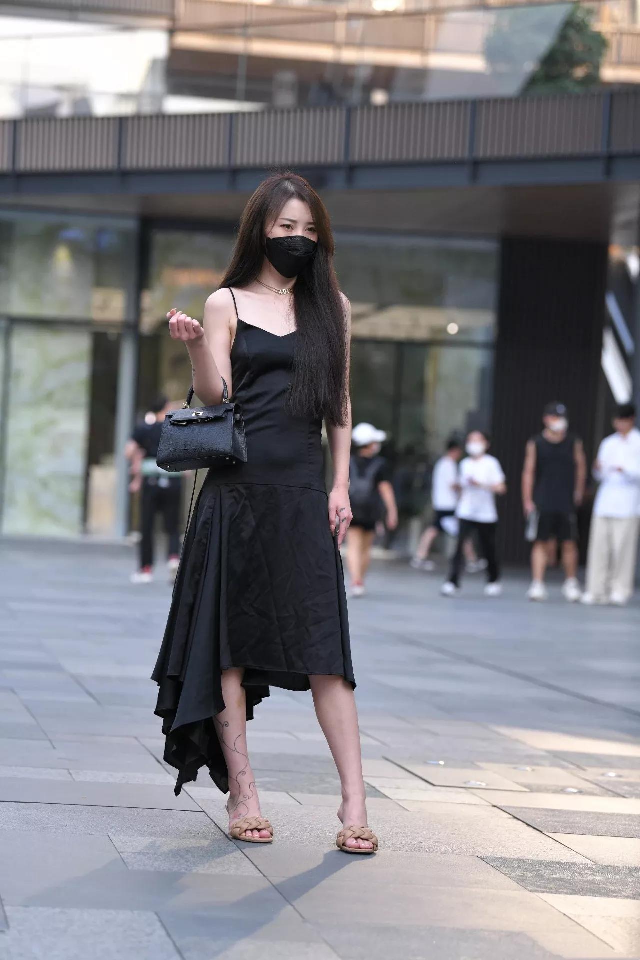 穿黑色吊带连衣长裙的时尚女生