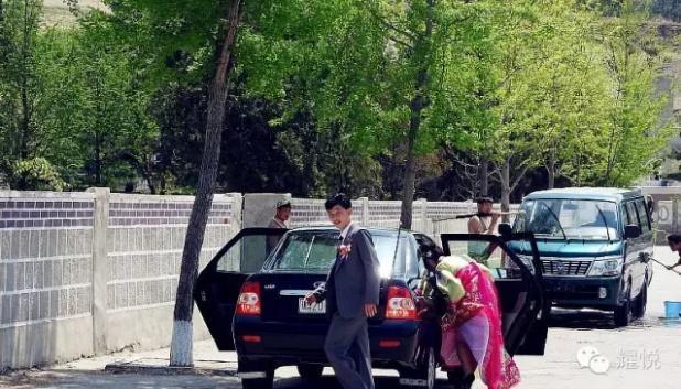 朝鲜的街头，新娘穿着艳丽的民族服装，很拘谨，羞涩的低头弄衣角
