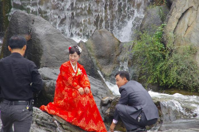 朝鲜的街头，新娘穿着艳丽的民族服装，很拘谨，羞涩的低头弄衣角